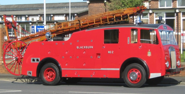 a vintage fire truck with wooden ladders and flat screen